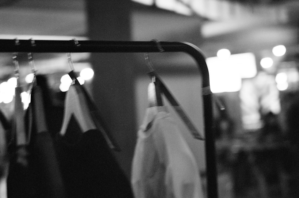 a black and white photo of clothes hanging on a rail
