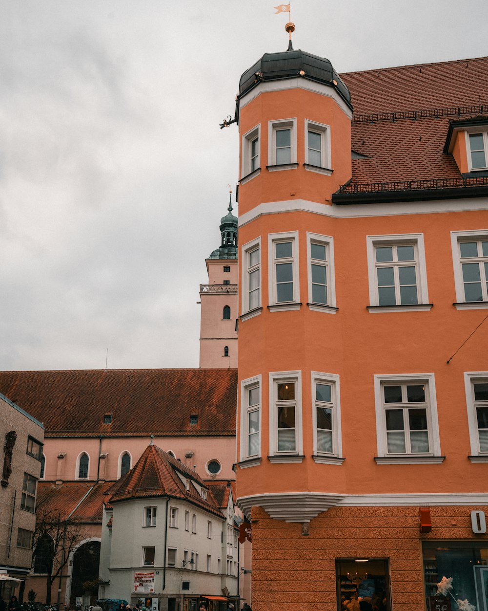 a tall orange building sitting next to a tall white building