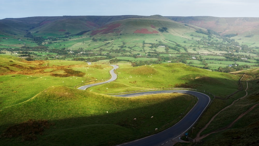 a winding road winding through a lush green valley