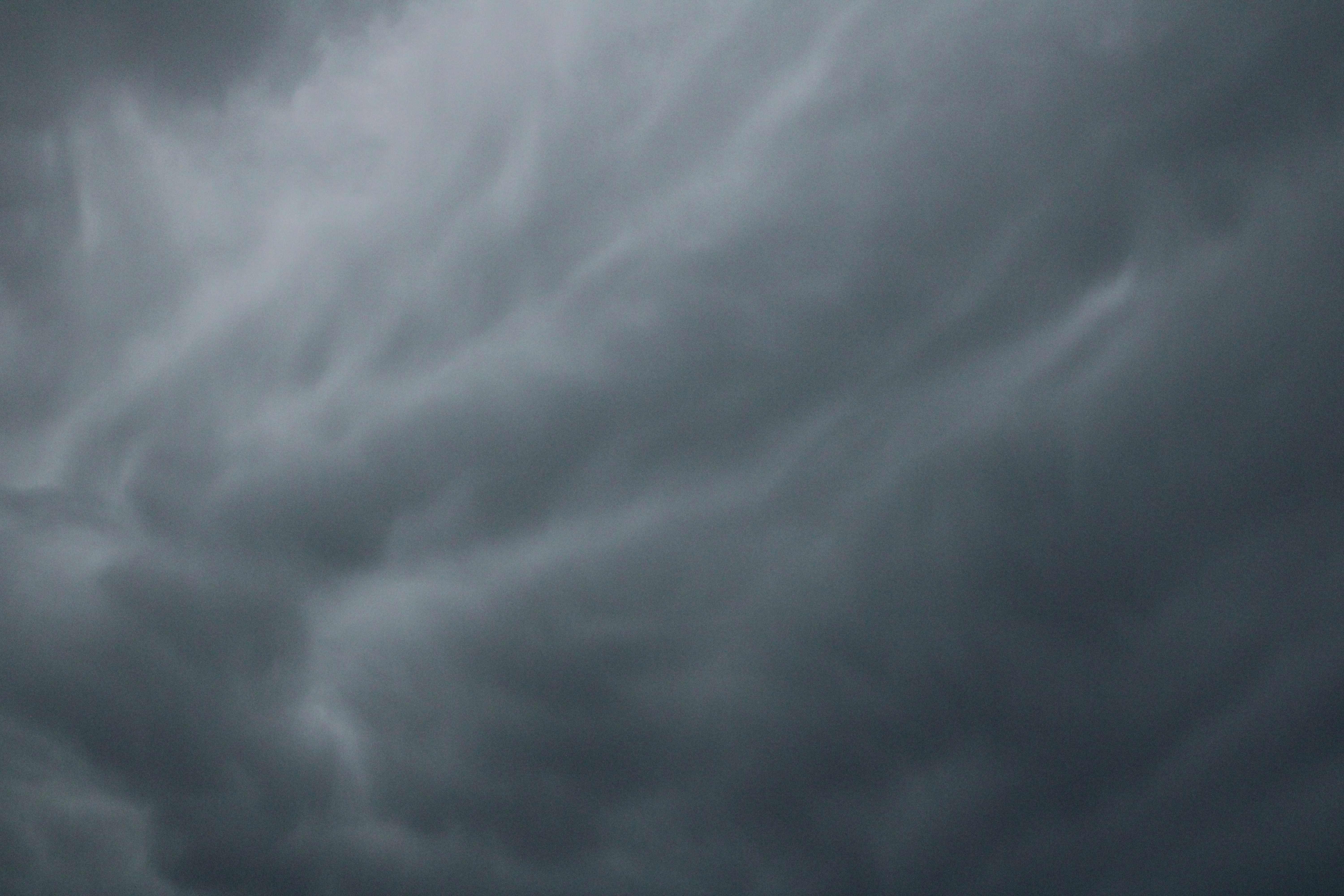 a plane flying through a cloudy sky on a cloudy day