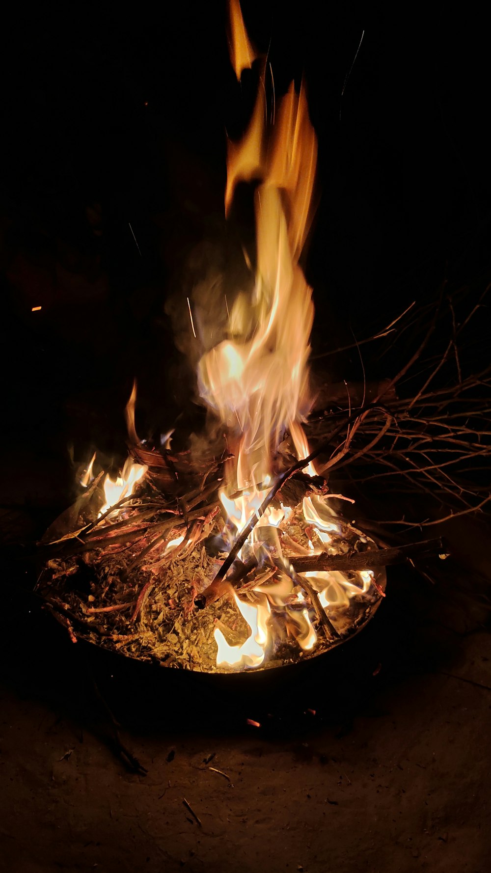a fire burning in the middle of a dark area