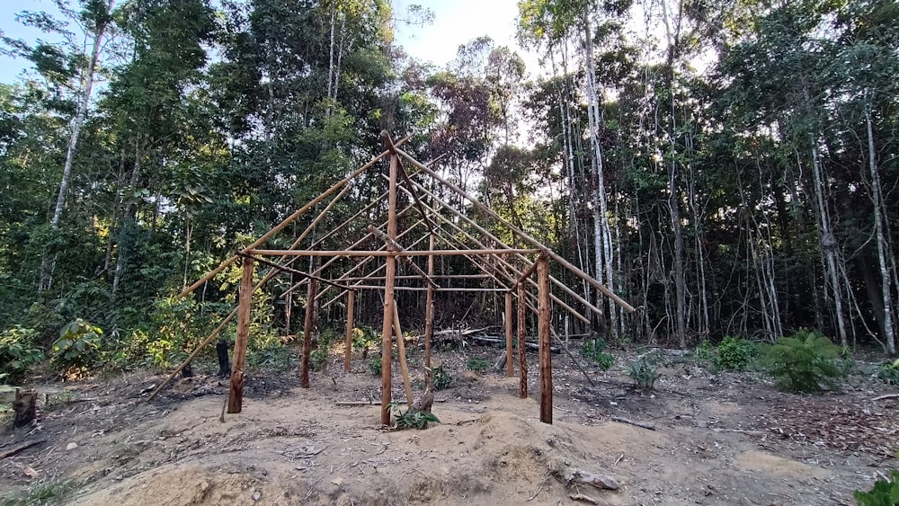 a wooden structure sitting in the middle of a forest