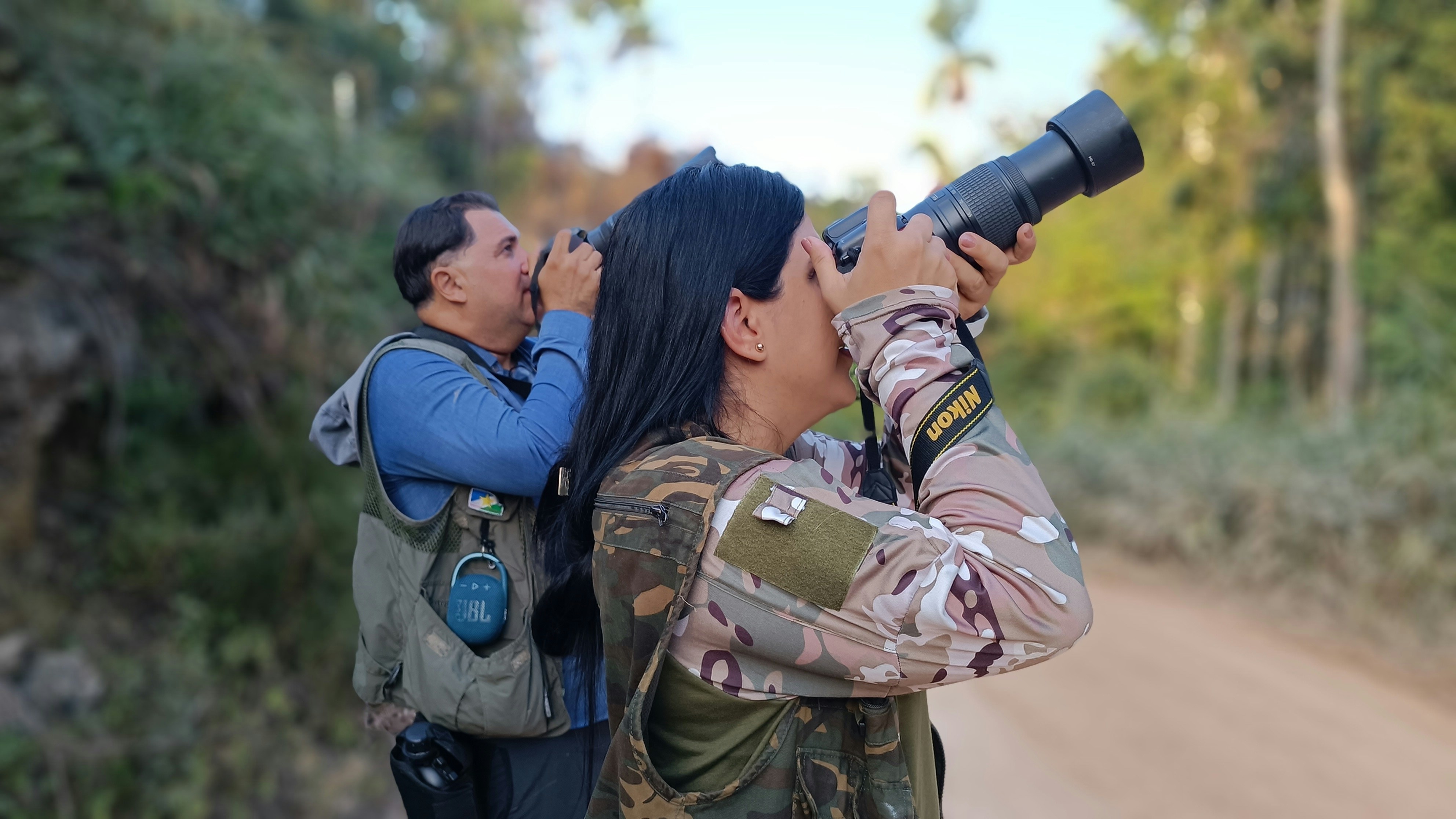 Fotomural a woman taking a picture of another woman with a camera
