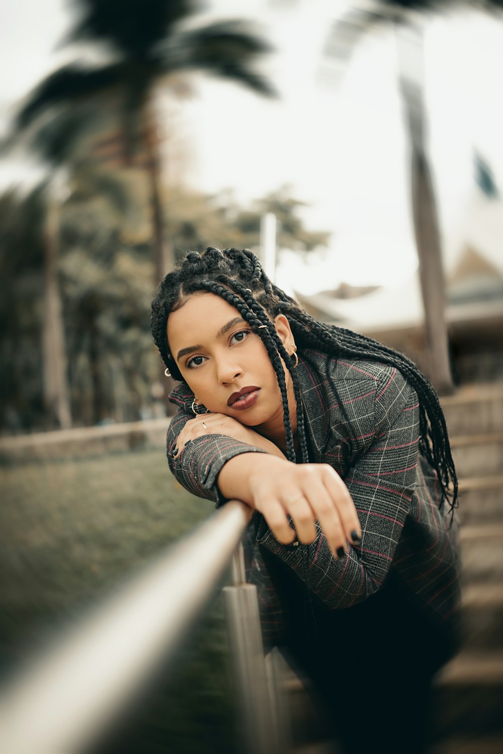 a woman with dreadlocks leaning on a rail