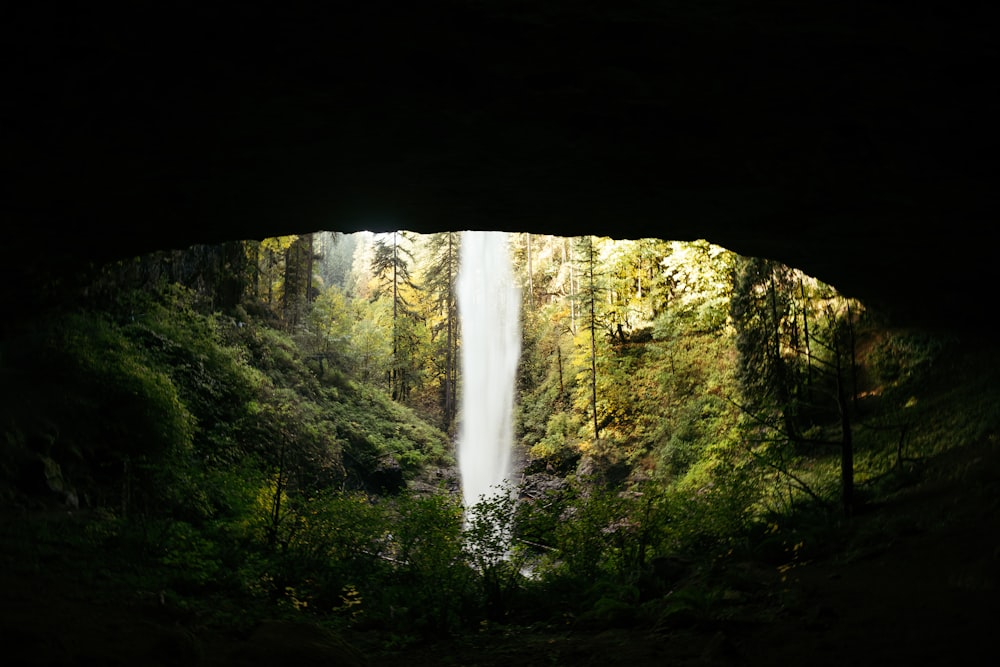 a view of a waterfall through a cave