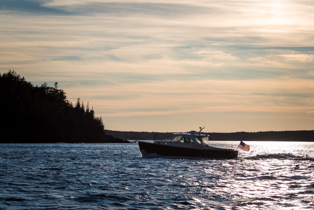 a boat traveling on the water at sunset