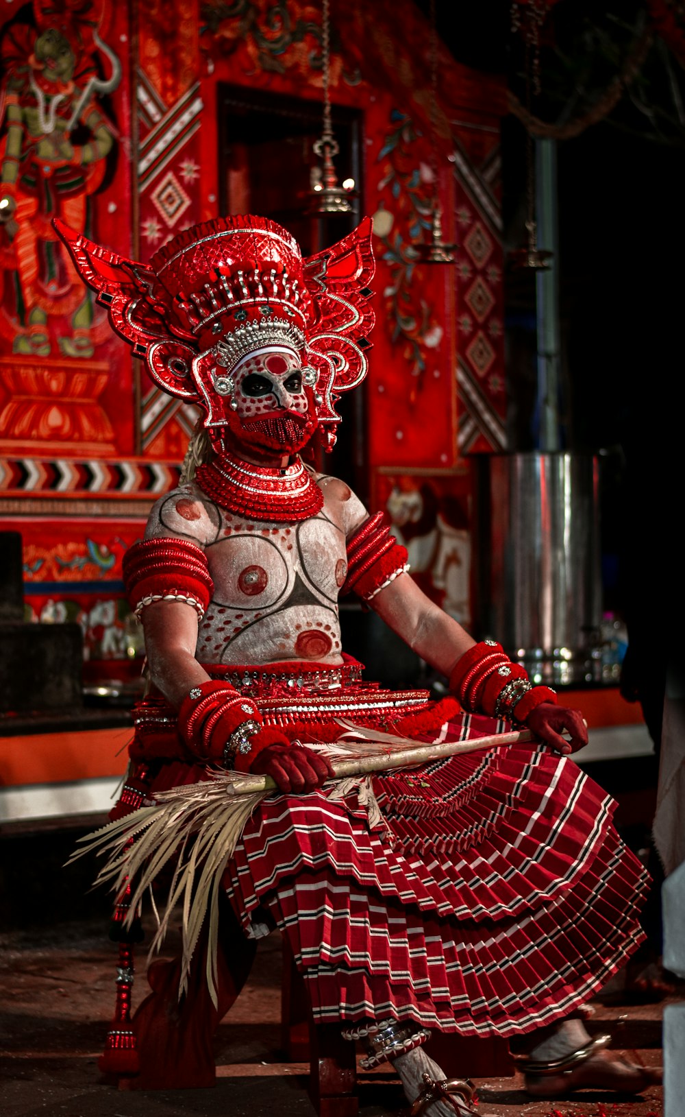 a woman in a red and white costume sitting on a stool