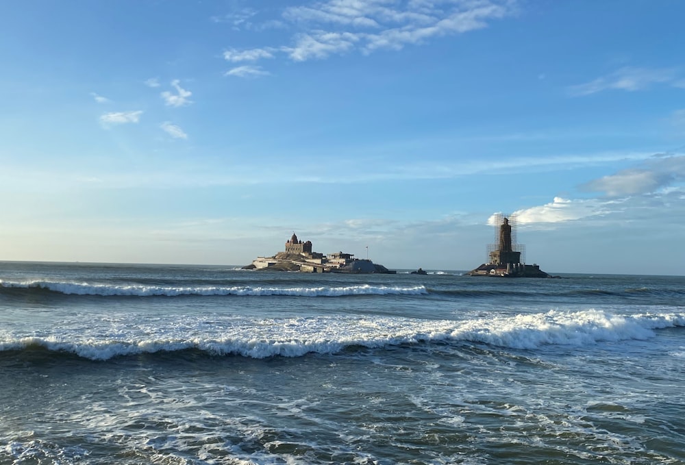 a large body of water with a lighthouse in the background