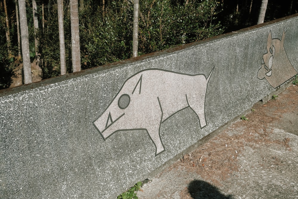 a concrete wall with a drawing of a pig on it