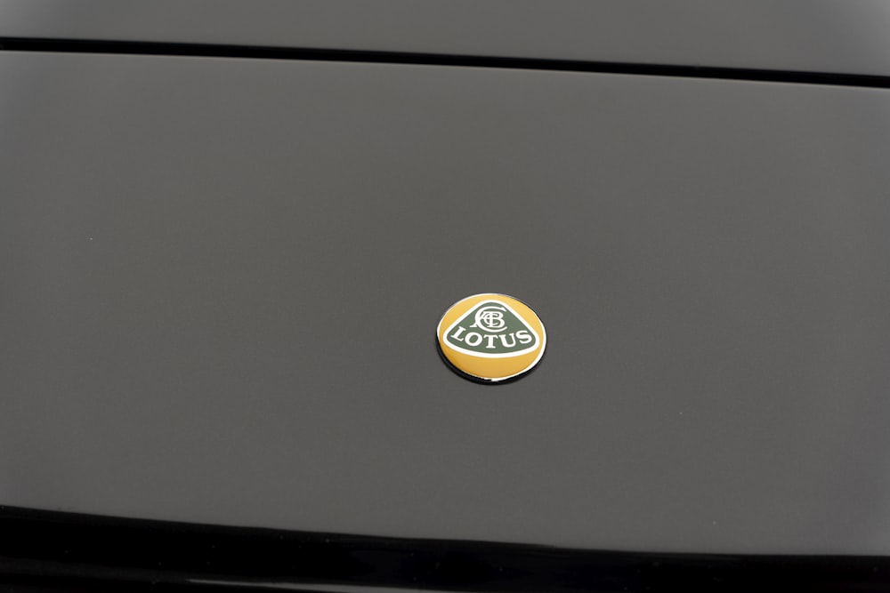 a close up of a black car with a yellow sticker on it