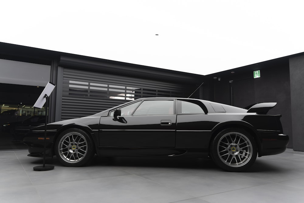 a black sports car parked in front of a garage