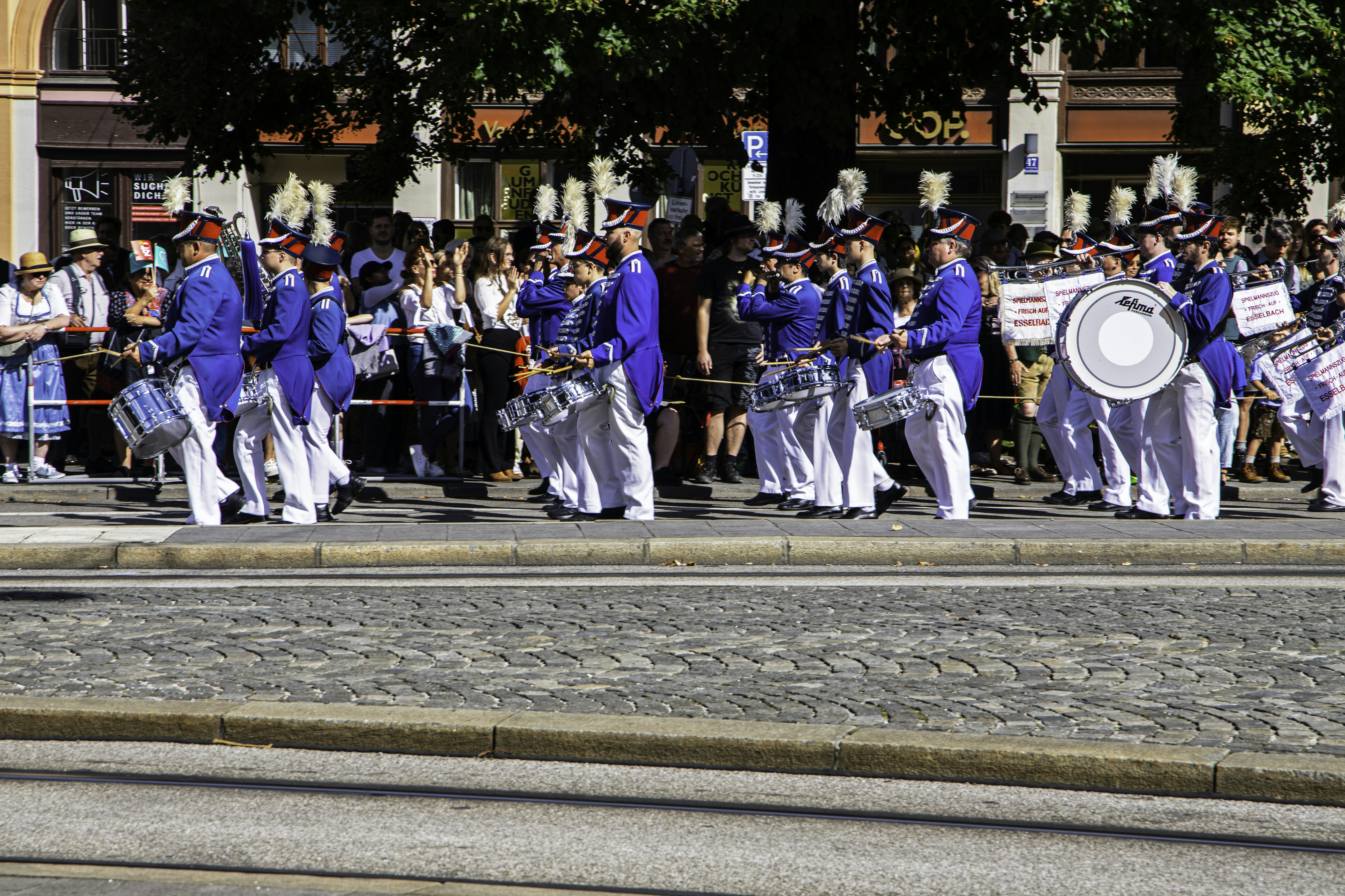 a group of men in blue and white uniforms marching down a street