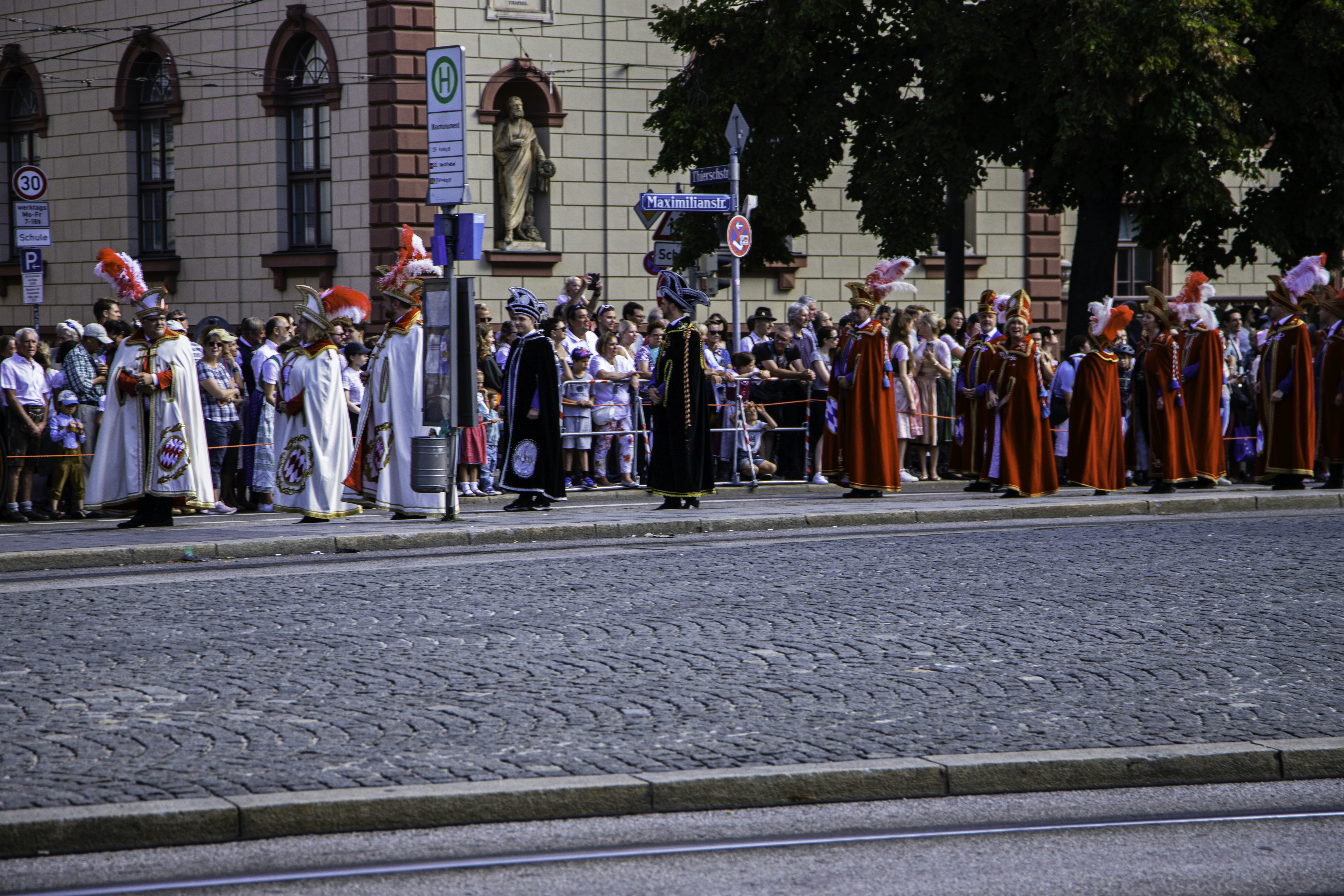 a group of people standing on the side of a road, 
