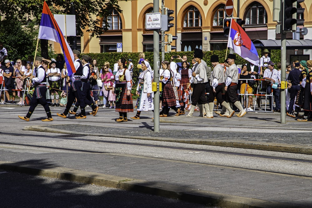 a group of people walking down a street holding flags