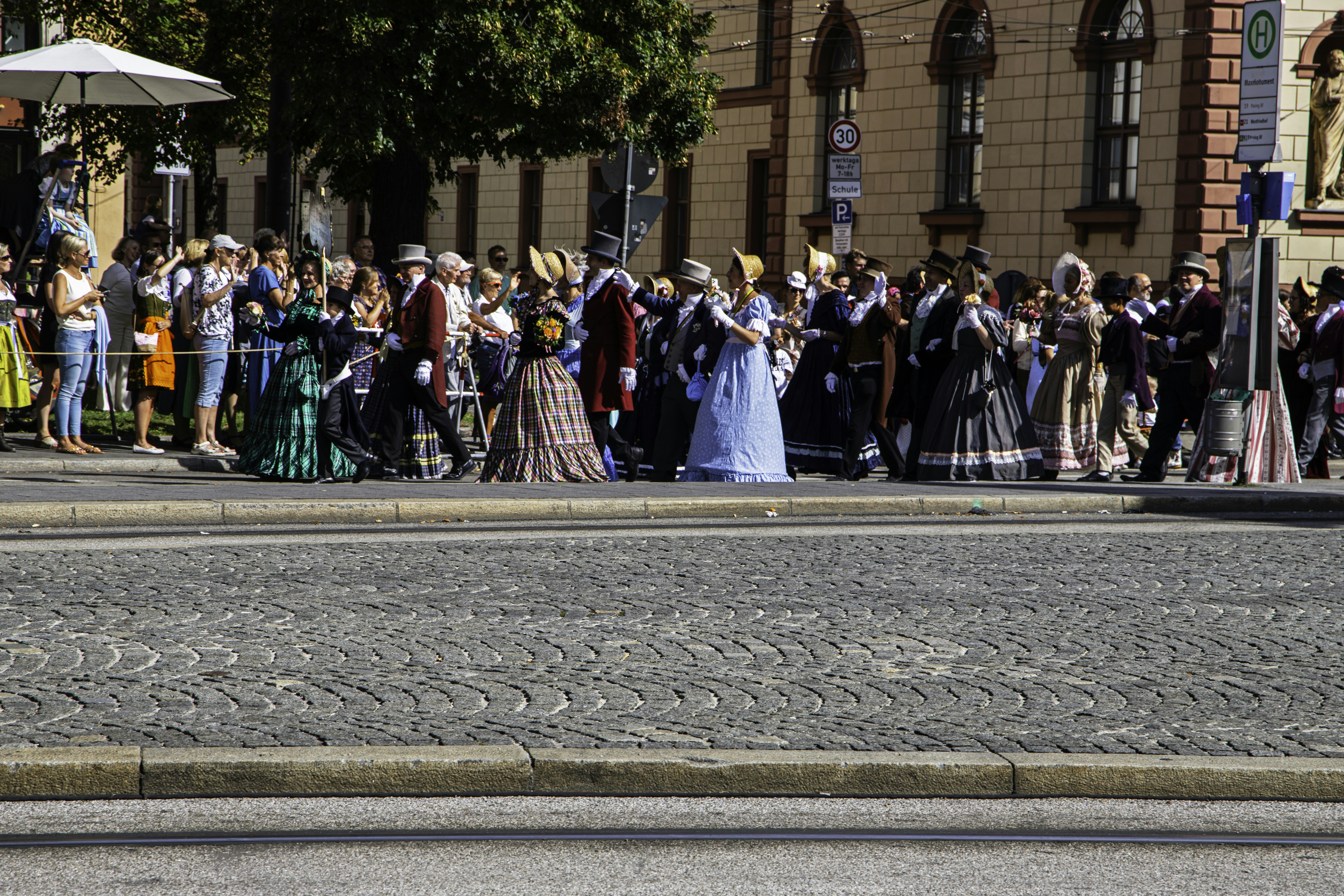 a group of people standing on the side of a road, 