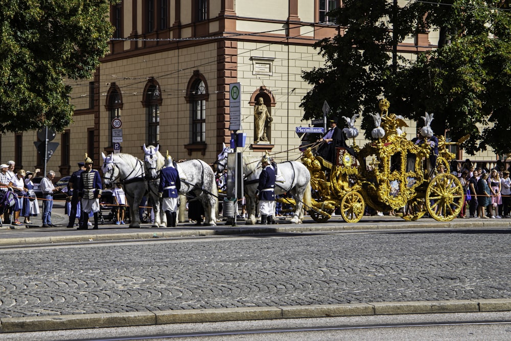a group of people standing next to a horse drawn carriage