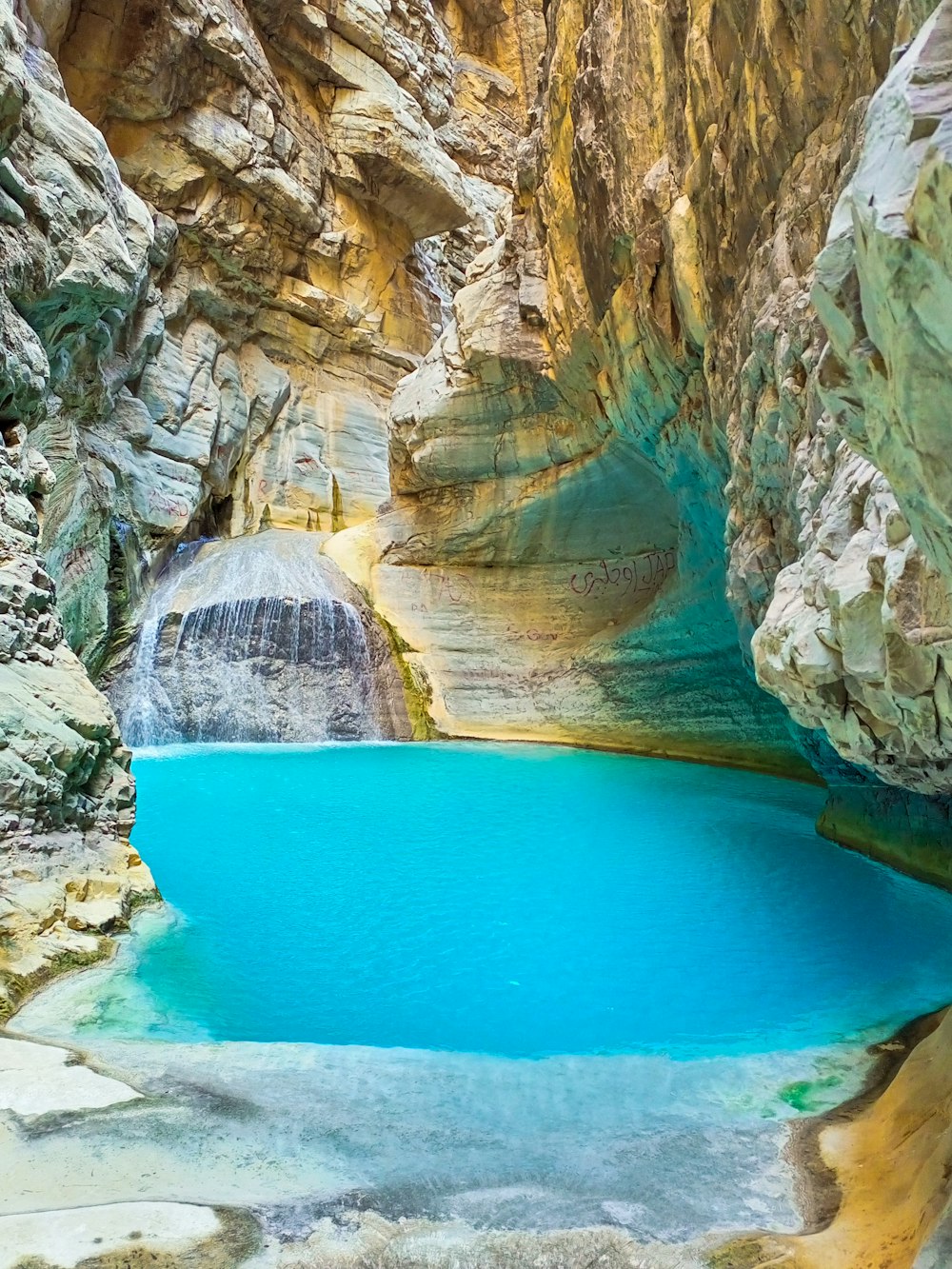 a blue pool of water in a canyon