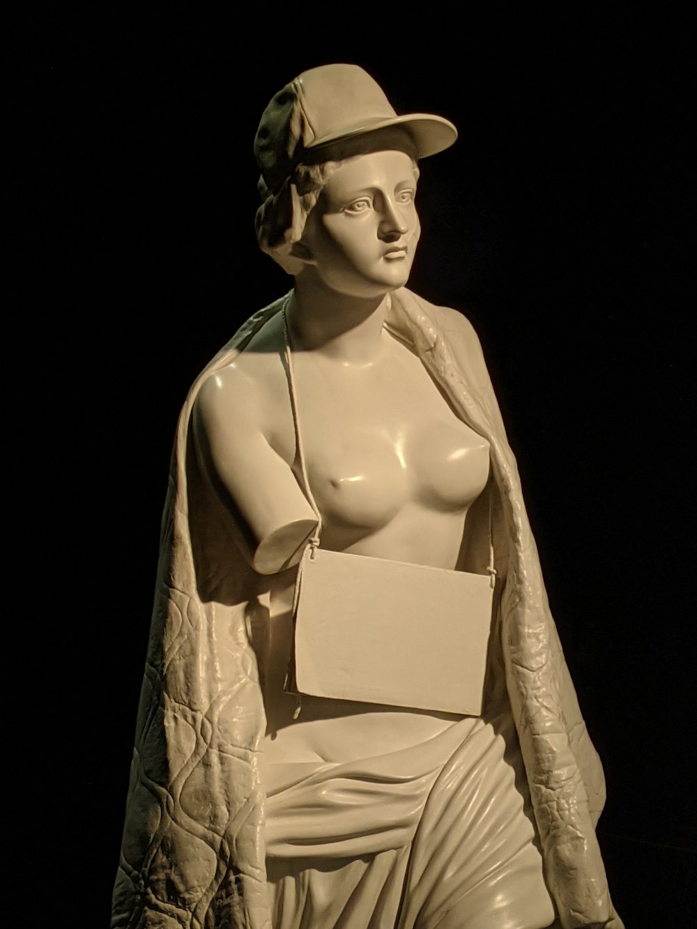 a statue of a woman wearing a hat and holding a piece of paper