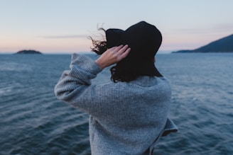 a woman standing on a boat looking out at the ocean