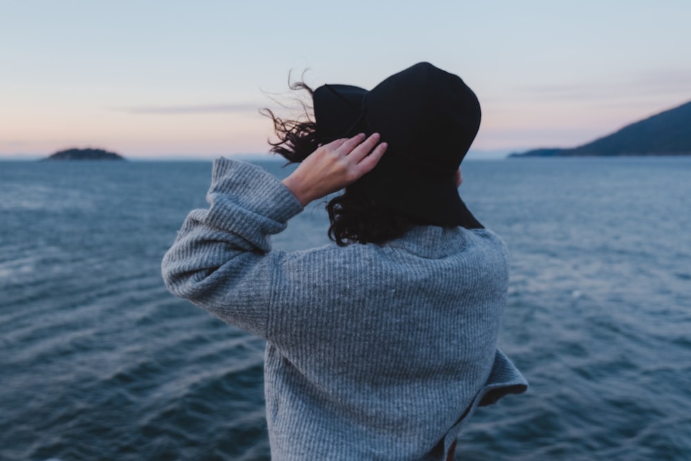 a woman standing on a boat looking out at the ocean