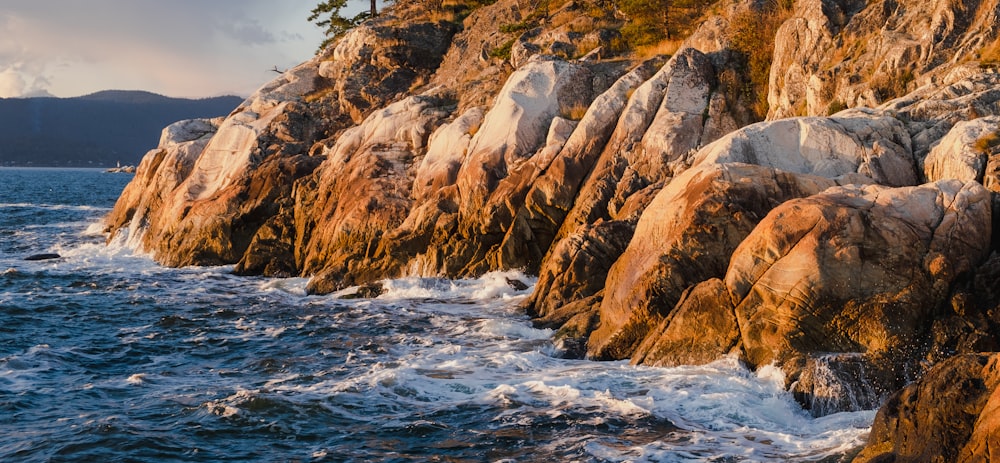 a rocky shoreline with waves crashing against the rocks