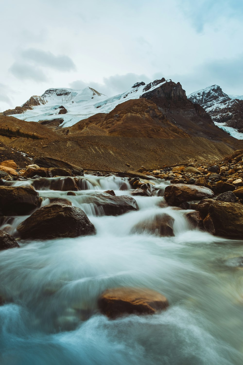 a stream of water running through a rocky mountain valley