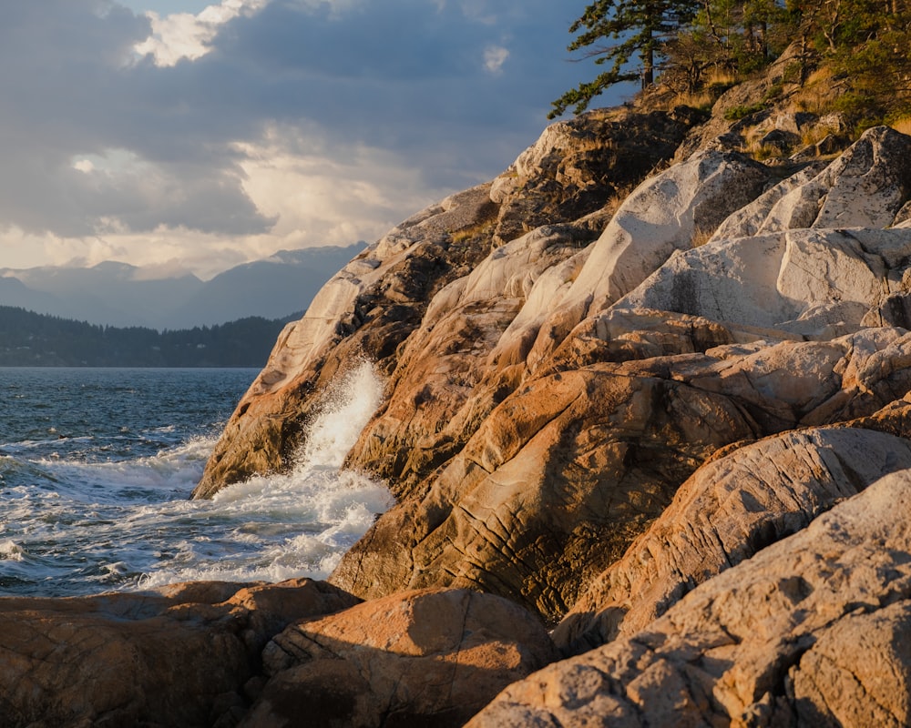 a rocky shore line with waves crashing against the rocks