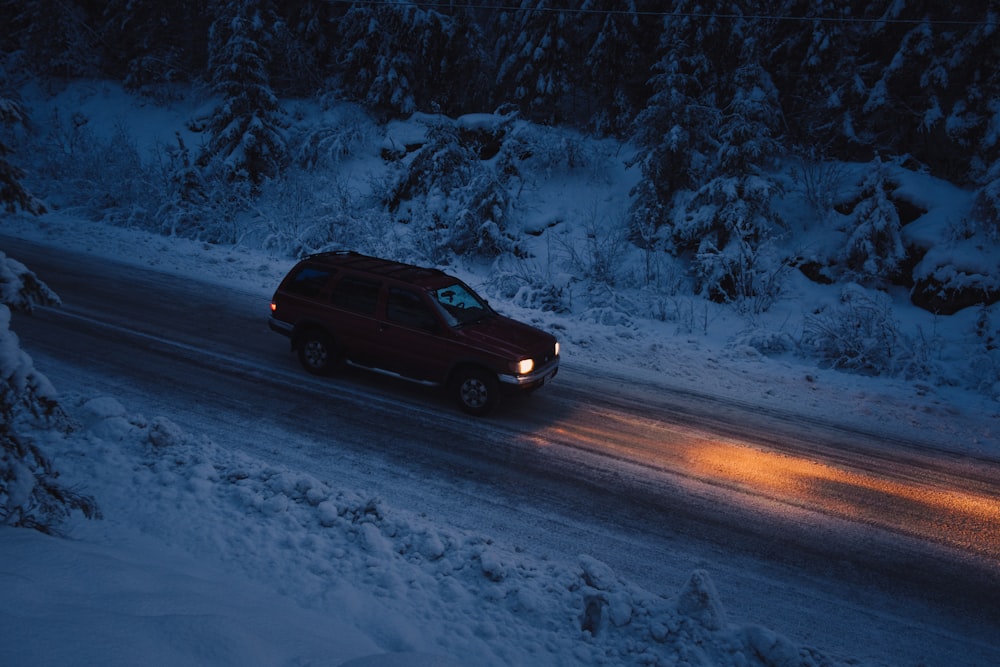 a car driving down a snowy road at night