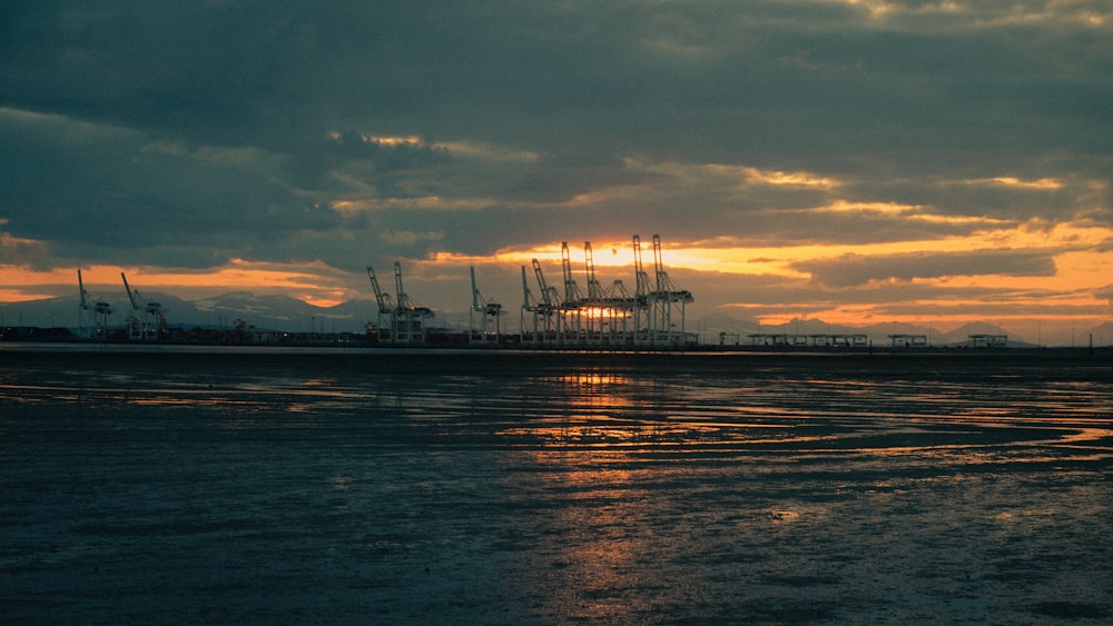 the sun is setting over a harbor with ships