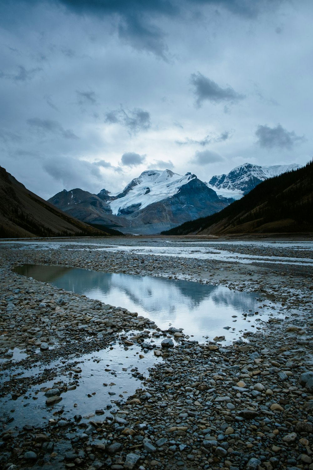 a mountain range with a body of water in the foreground