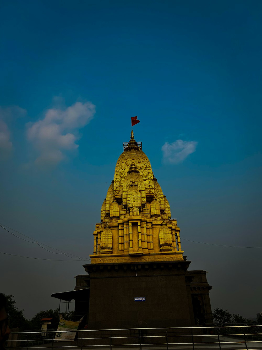 a tall yellow building with a flag on top