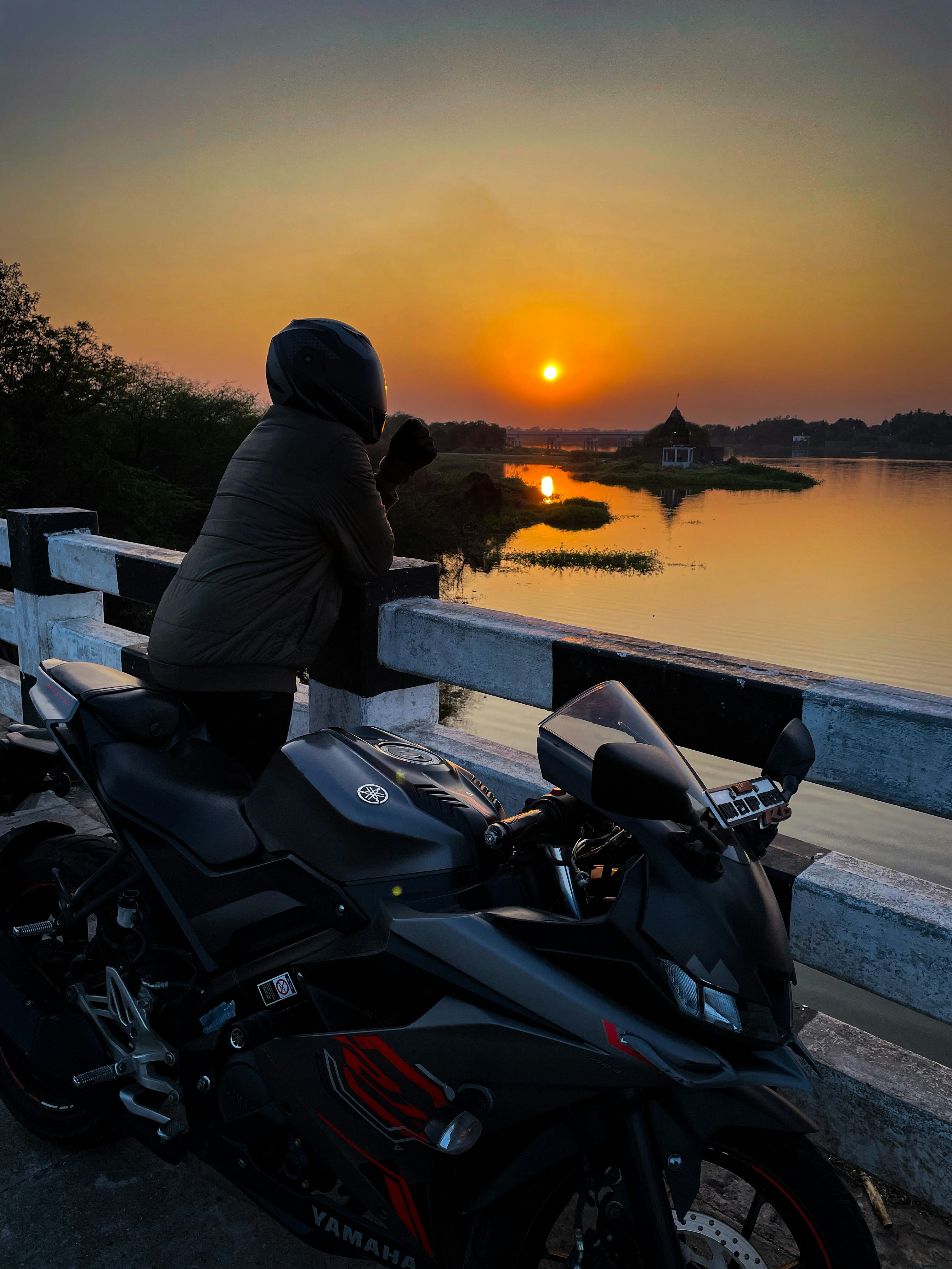 a person sitting on a motorcycle looking at the sunset