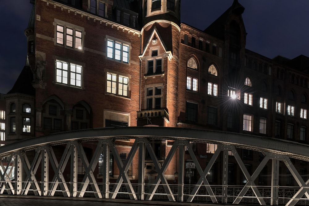 Un gran edificio con una torre de reloj iluminada por la noche