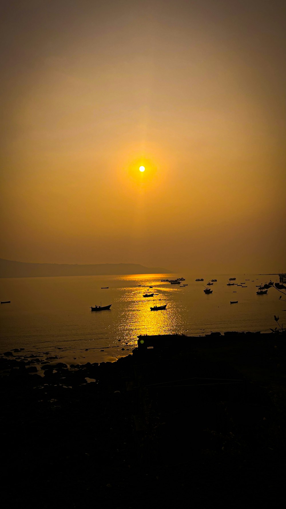 a sunset over a body of water with boats in the water