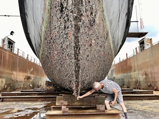 a man working on a large boat in a dry dock
