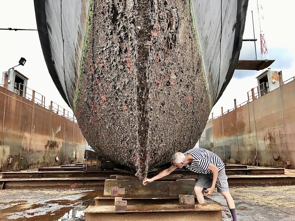 Un homme travaillant sur un grand bateau en cale sèche