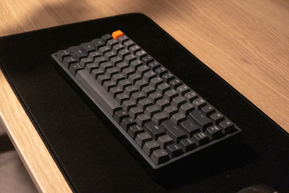 a computer keyboard sitting on top of a wooden desk