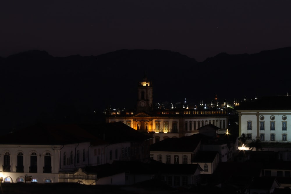 a city at night with a clock tower in the background