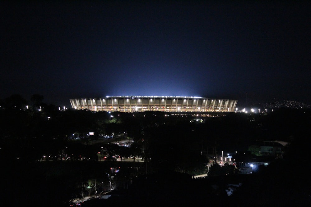 a stadium lit up at night with the lights on