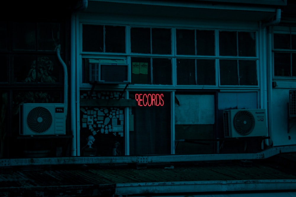 a red neon sign that is on the side of a building