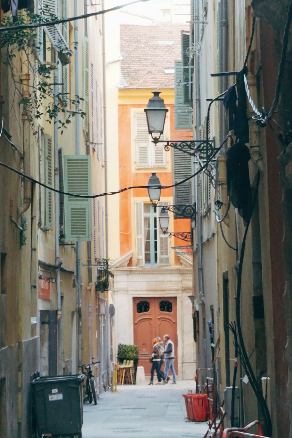 a narrow alley way with people walking down it