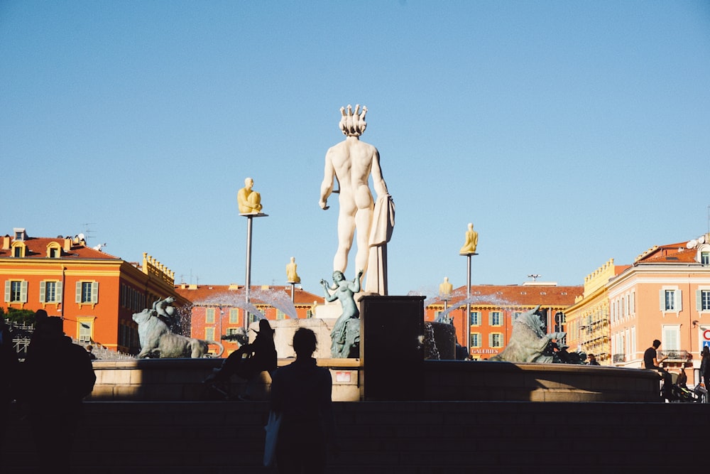 a group of people standing around a statue