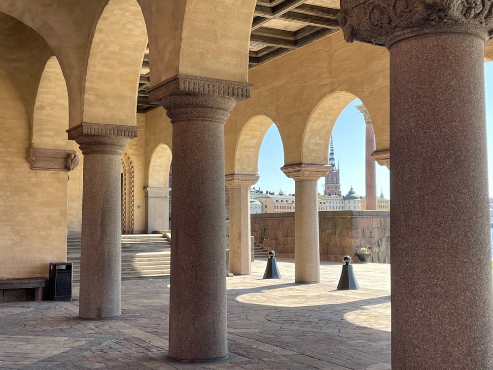 a row of pillars with a clock tower in the background