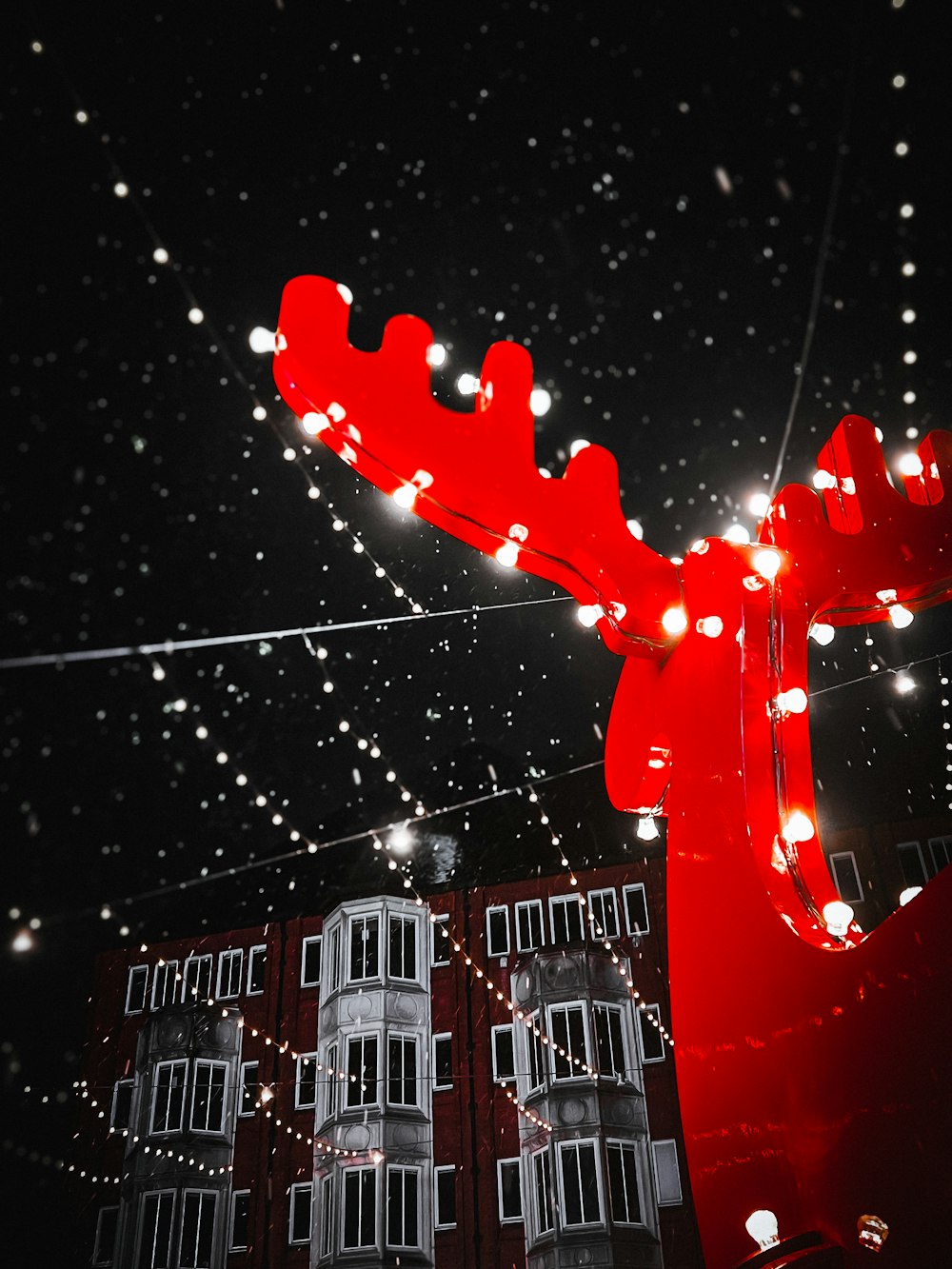 a large red moose statue with lights on it's back