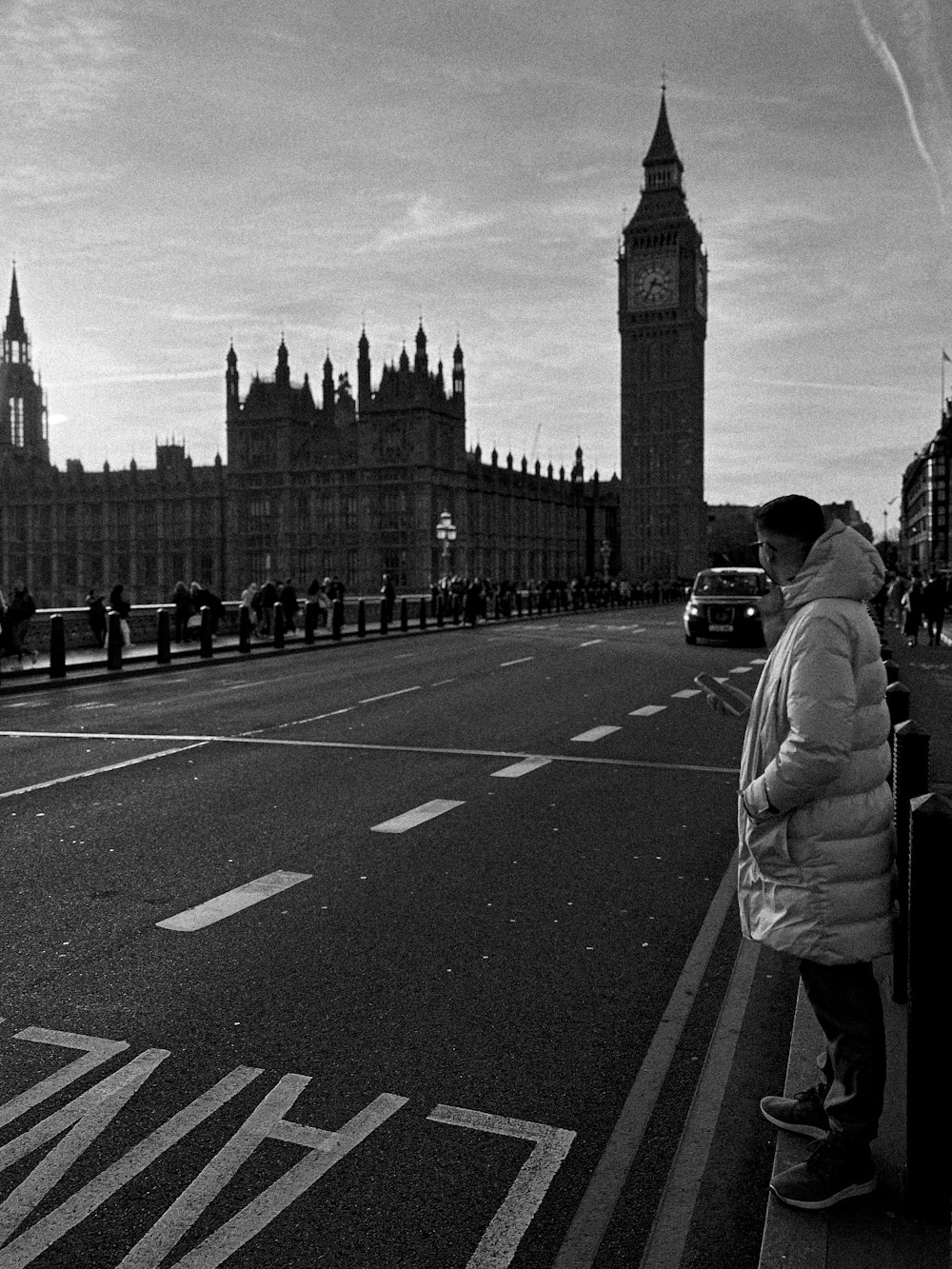 a man standing on the side of a road next to a tall building