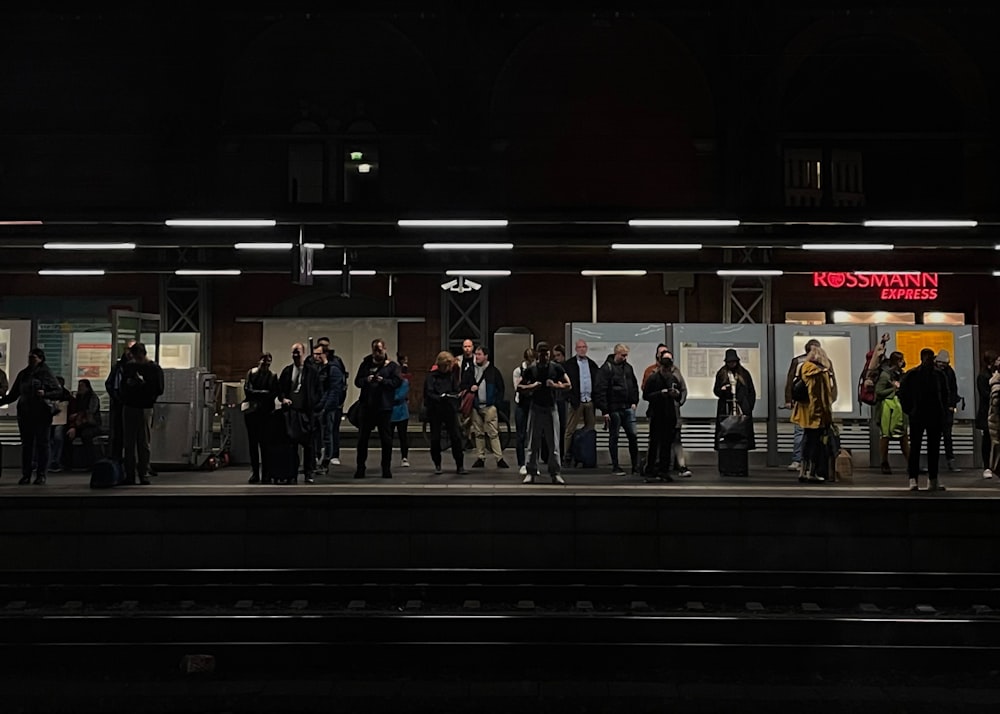 a group of people standing on a train platform
