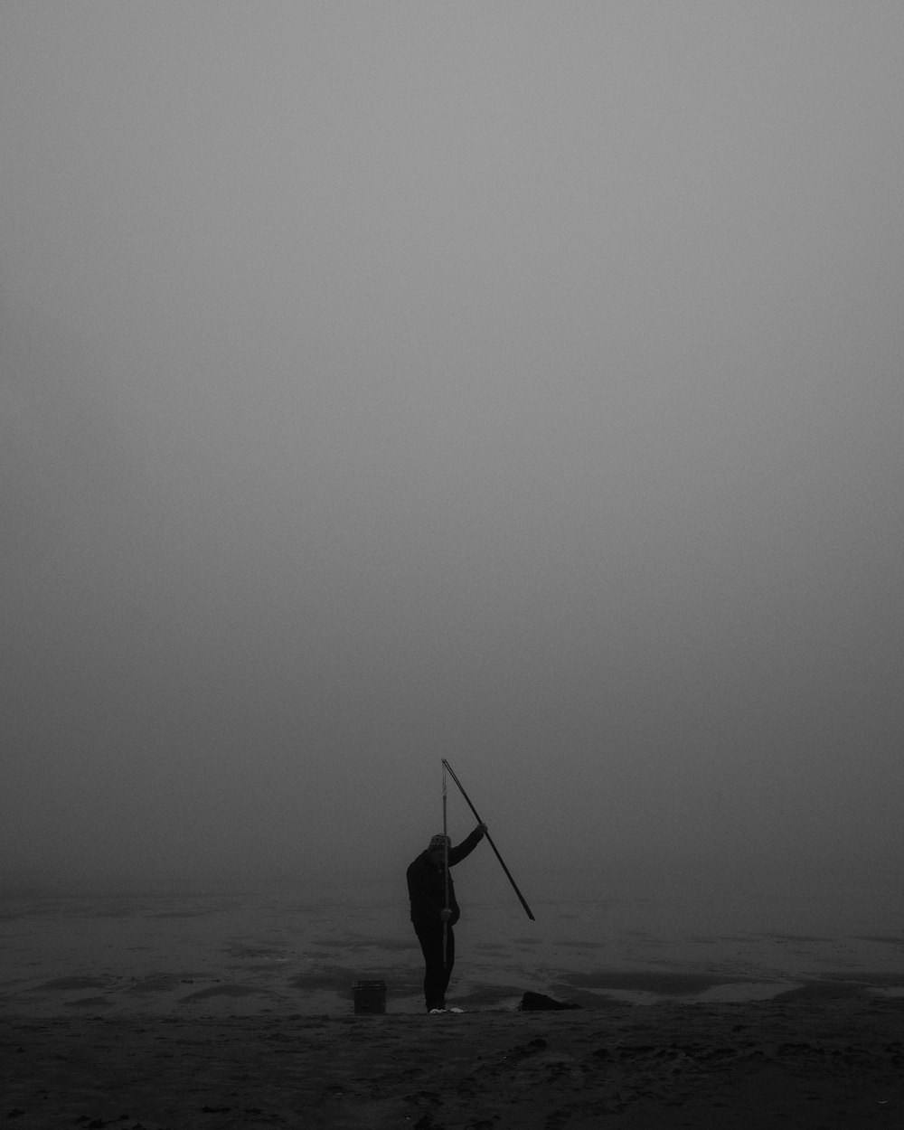 a man standing on top of a beach holding a surfboard