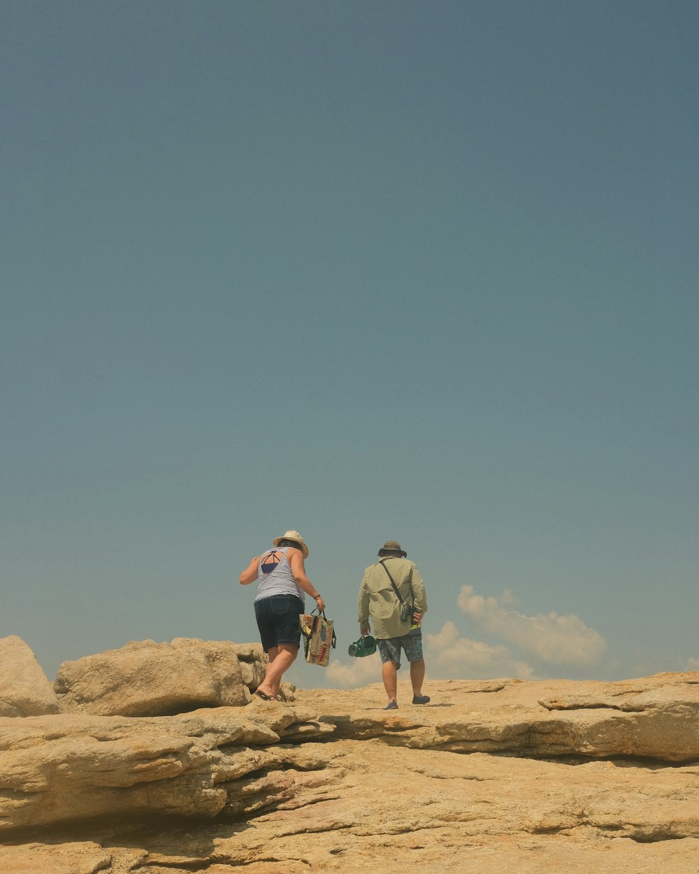 a couple of people standing on top of a rocky hill