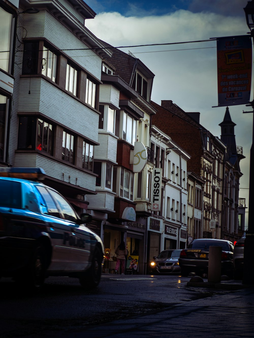 a car driving down a street next to tall buildings