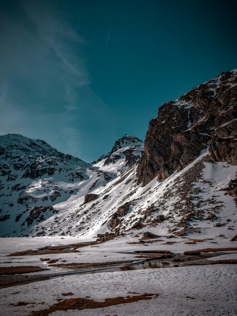 a snow covered mountain side under a blue sky